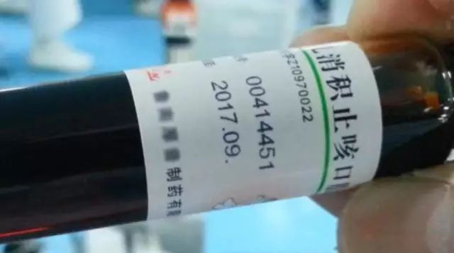 手持深色瓶子标签上的批次数字与2017.09文字