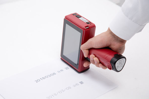 手握红色屏幕设备与纸上的日期字符