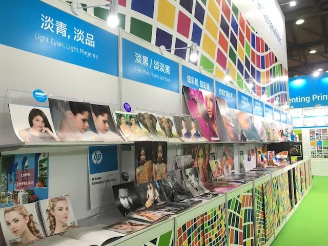 www.eamar_.com_.cn-hp657854 展位上陈列的彩色人像印品与色块布景