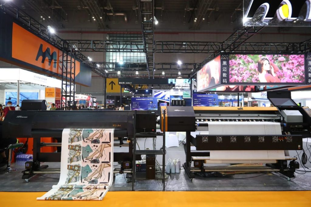 黑迈数码展台上的两台设备及垂挂彩色图样
