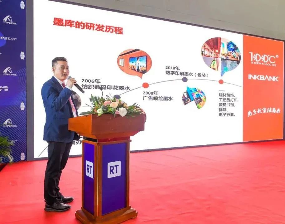 男子在讲台旁展示墨库研发过程幻灯片