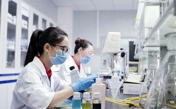 戴口罩和手套的人员手持幼瓶与手持仪器