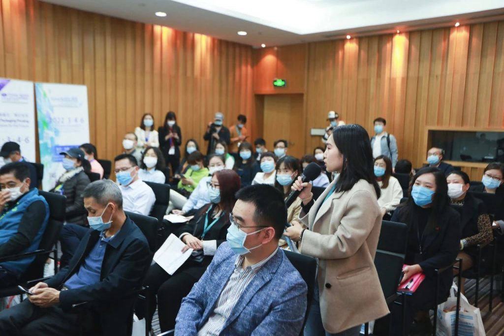 会议室中持麦克风的女子与周围听多